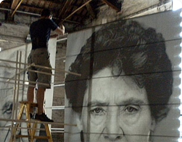 Installing a giant portrait print on scaffolding